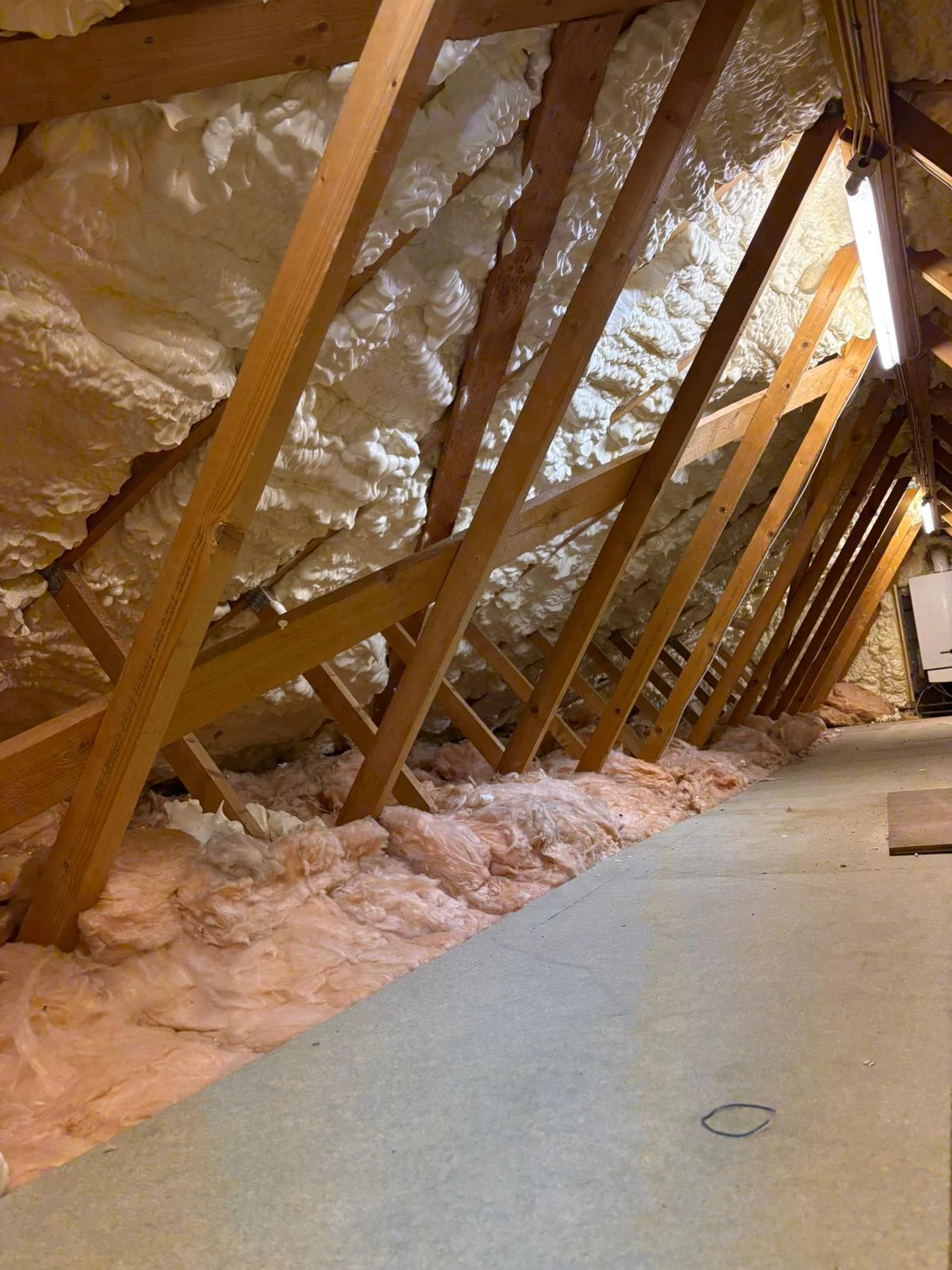 Spray foam insulation applied between roof timbers inside a residential loft space